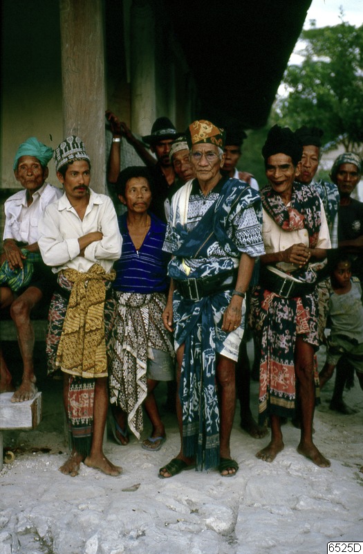 Group of men, central figure in a large patterned shoulder cloth