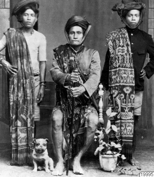 Studio portrait of three East Sumbanese men wearing hinggi ikat, colonial era